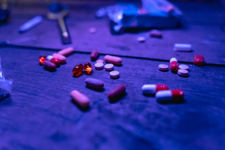 Assorted antibiotic pills and capsules scattered on a wooden surface, symbolizing the growing challenge of antibiotic resistance and emerging treatments like teixobactin.