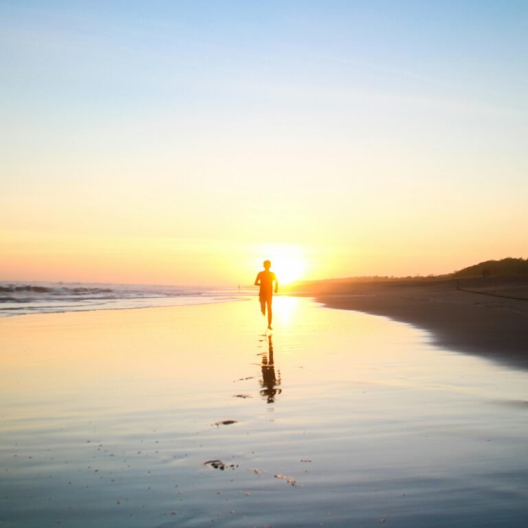 Silhouette of Boy Running in Body of Water during Sunset.